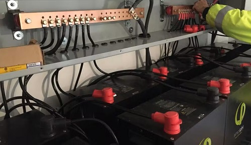 A bank of backup batteries wired into a residential electrical panel. 